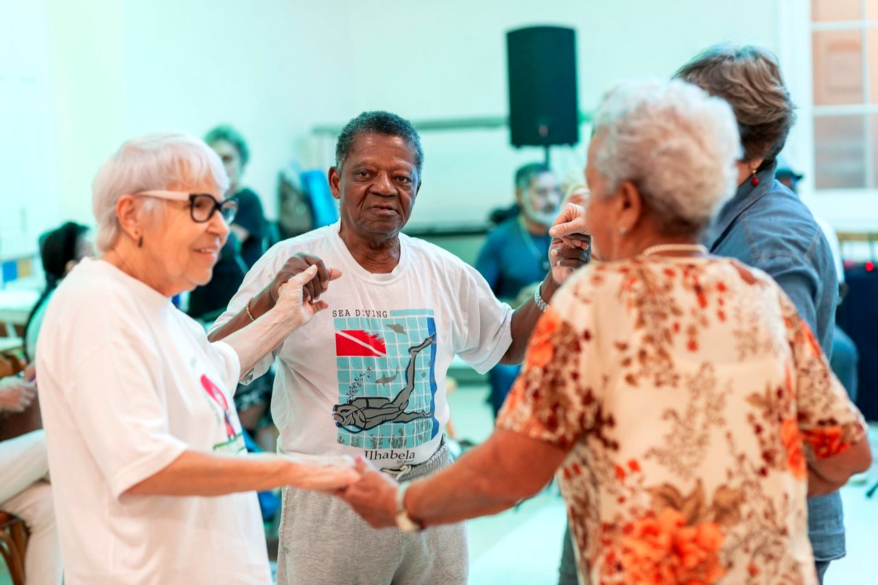Moradores dançando juntos no baile do Asilo Padre Cacique.